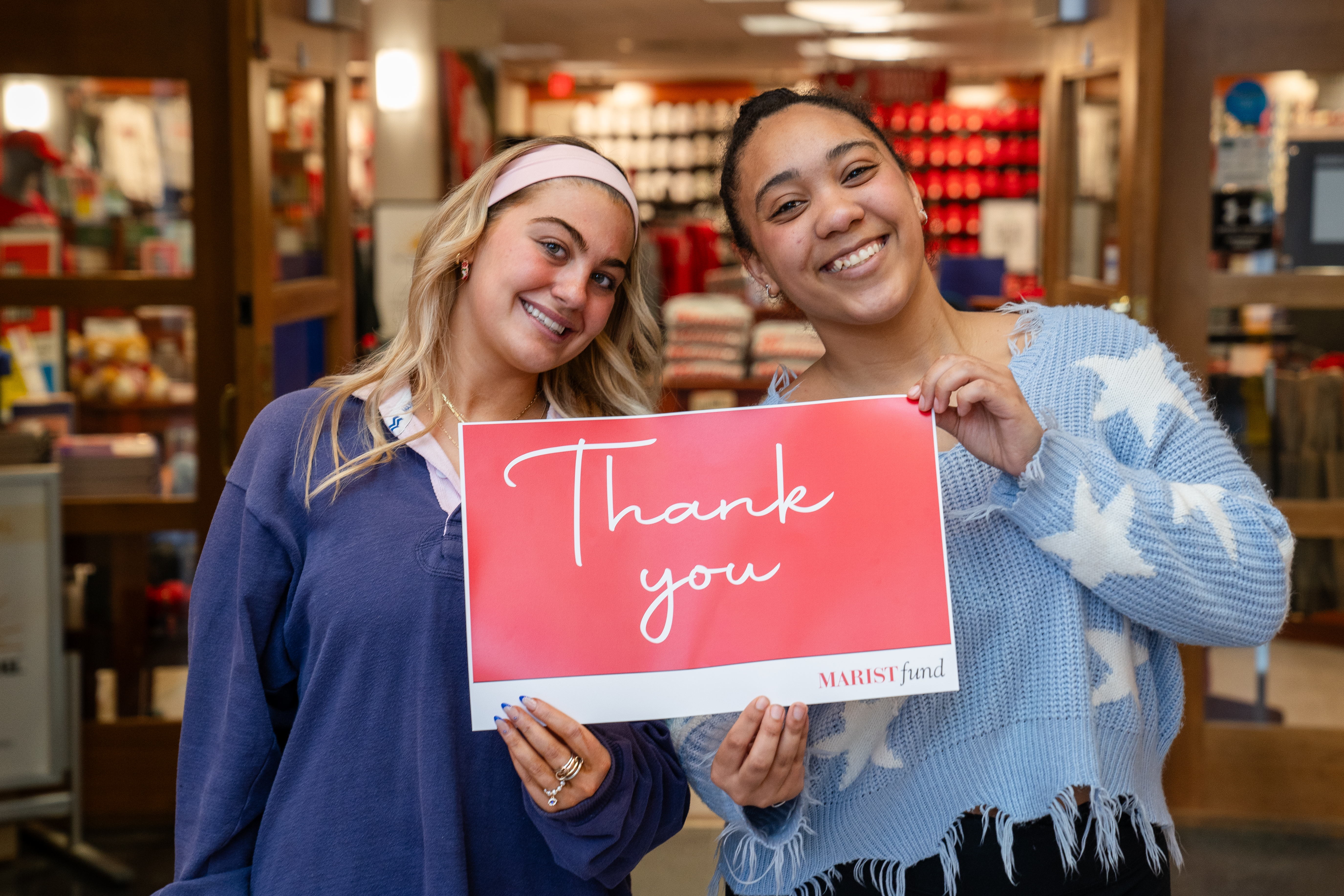 An image of two students holding a thank you sign. 