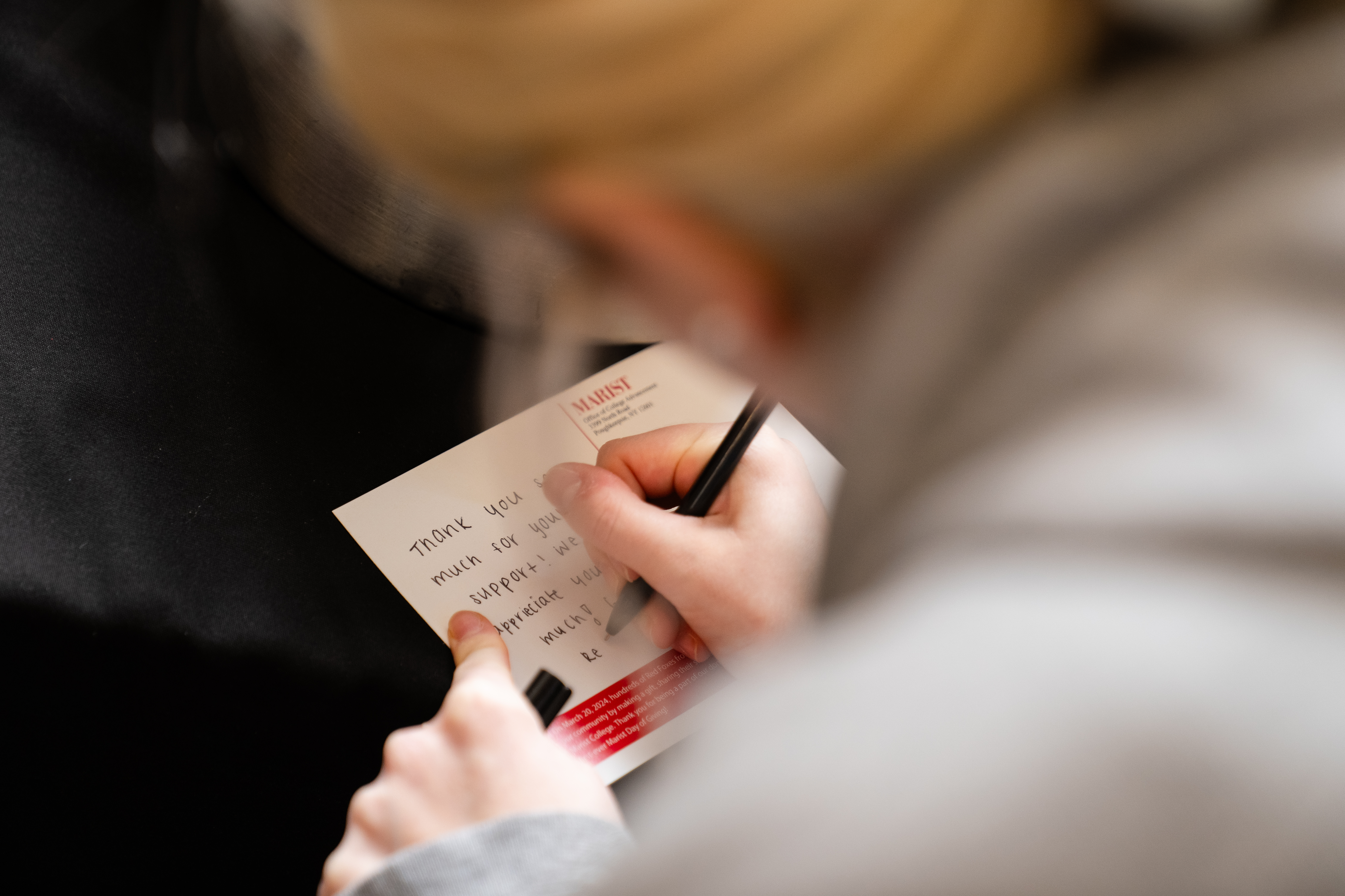 An image of a student writing a thank you card.