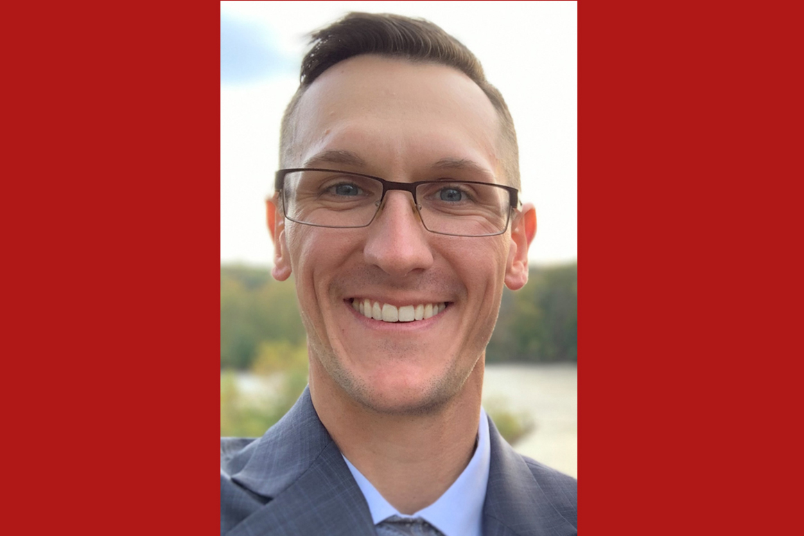 Image is a headshot of Matthew, a white man with blue eyes and glasses wearing a suit.