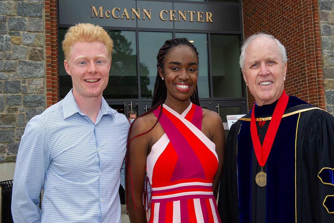 This is an image of President Dennis J. Murray congratulating 2021 Alumni Leadership Award winners Zachary F. Jacobs ’21 (left) and Natalie D. Ford ’21 following the Baccalaureate ceremony.